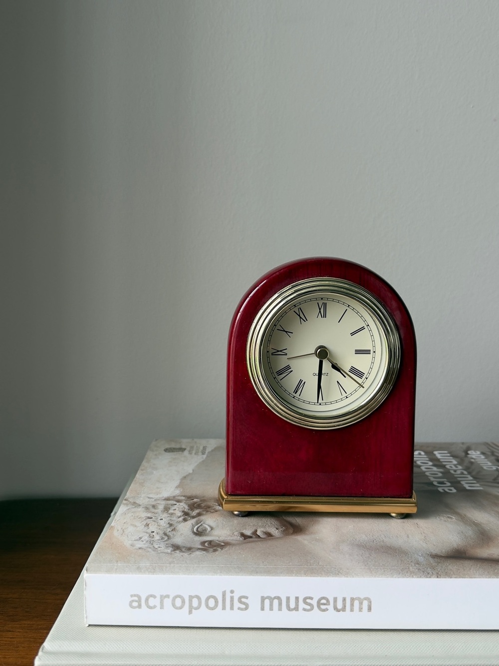 A piano finish arched desktop alarm clock in rosewood color.